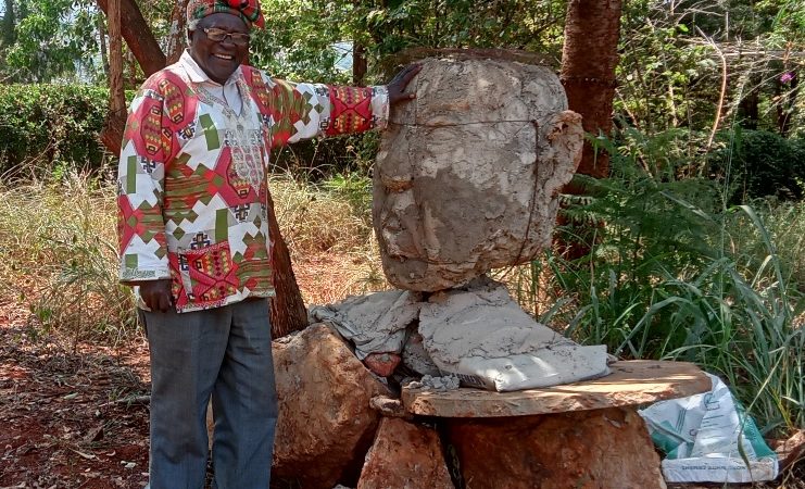 Sculptor David Maillu poses with the head the Shithole AKA Donald J Trump Statue at Mathemboni (Shrines) Centre, in Koola Village, Makueni County.